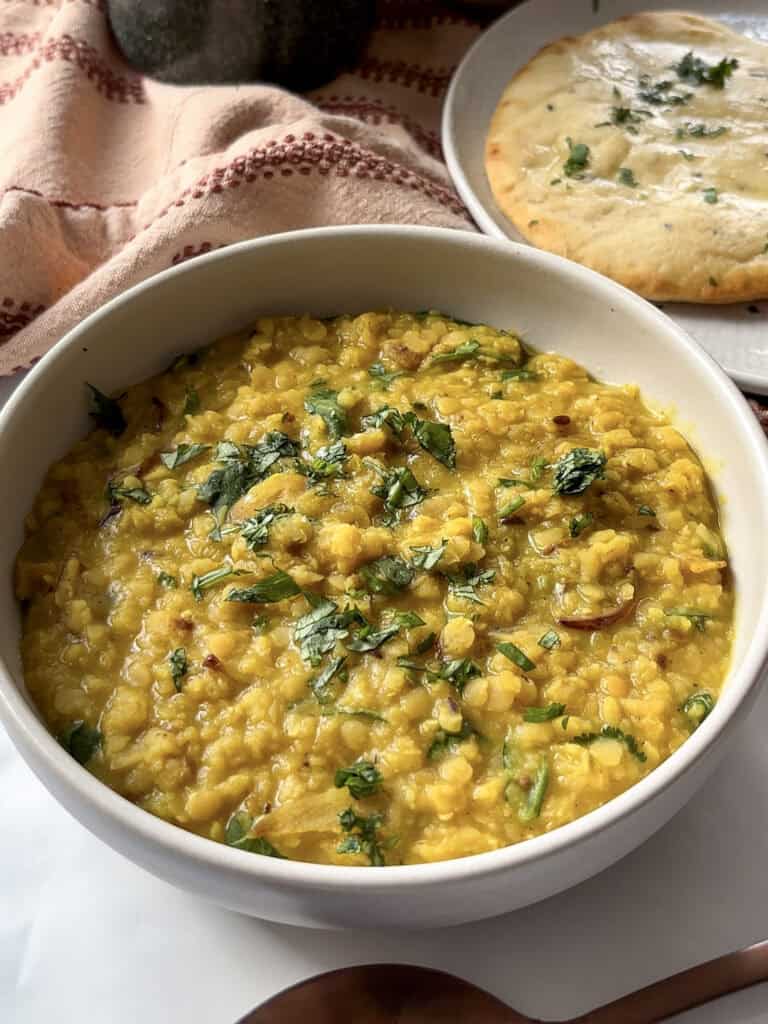 red lentil dahl in a bowl topped with chopped cilantro
