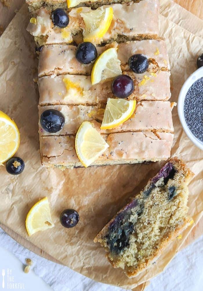 Slices of vegan lemon, blueberry, and poppy seed cake with fresh blueberries and lemon slices on top.