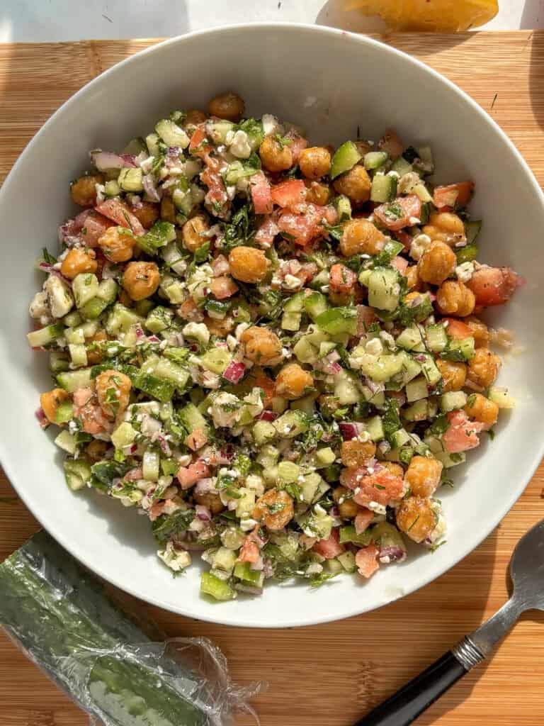 a lovely vibrant chickpea salad in a white salad bowl