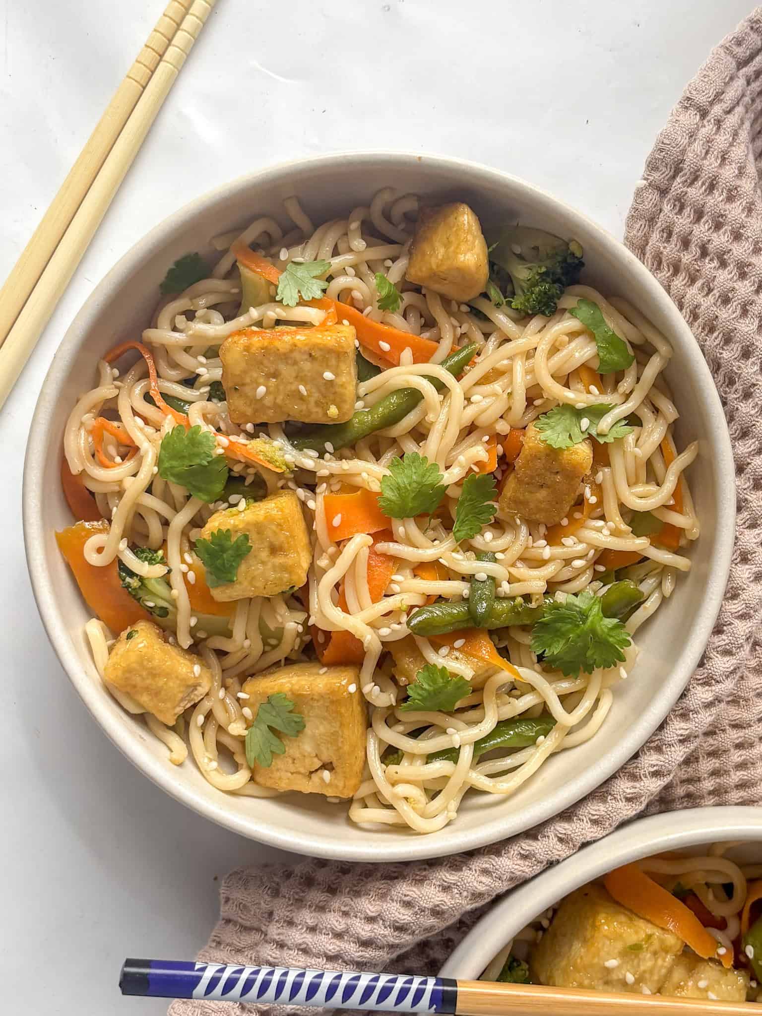 tofu noodle stir-fry topped with sesame seeds and cilantro leaves