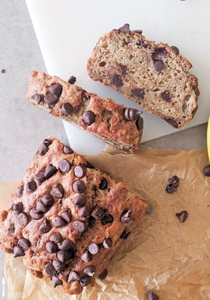 Chocolate chip banana loaf with two slices, one stacked vertically and one horizontally.