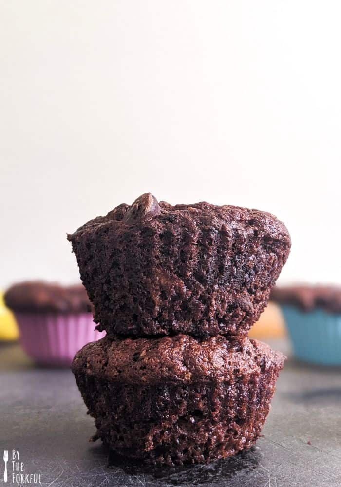 Vegan double chocolate chip banana muffins stacked on top of each other.