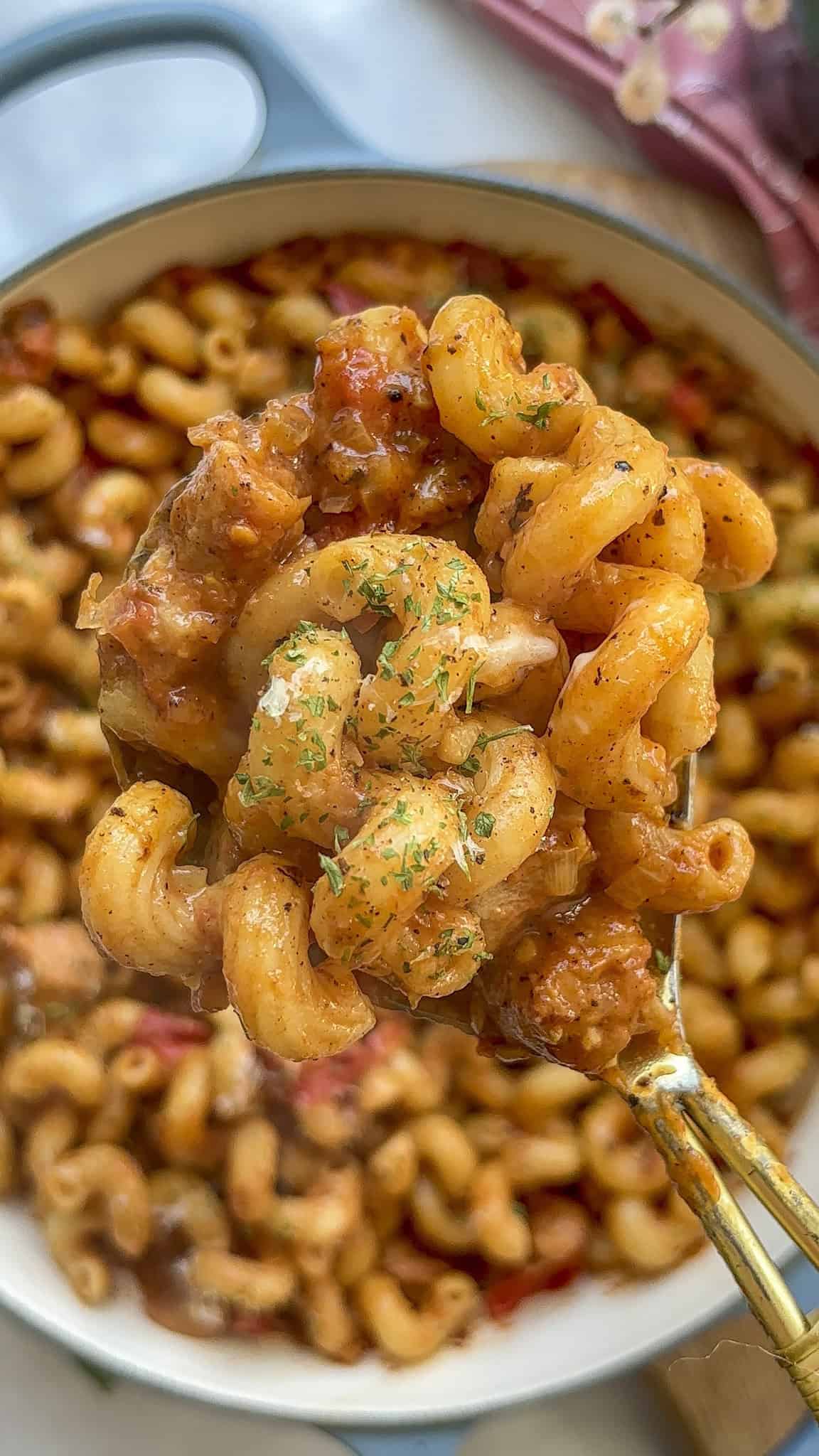 a large spoonful of creamy sausage pasta topped with parsley or cheese