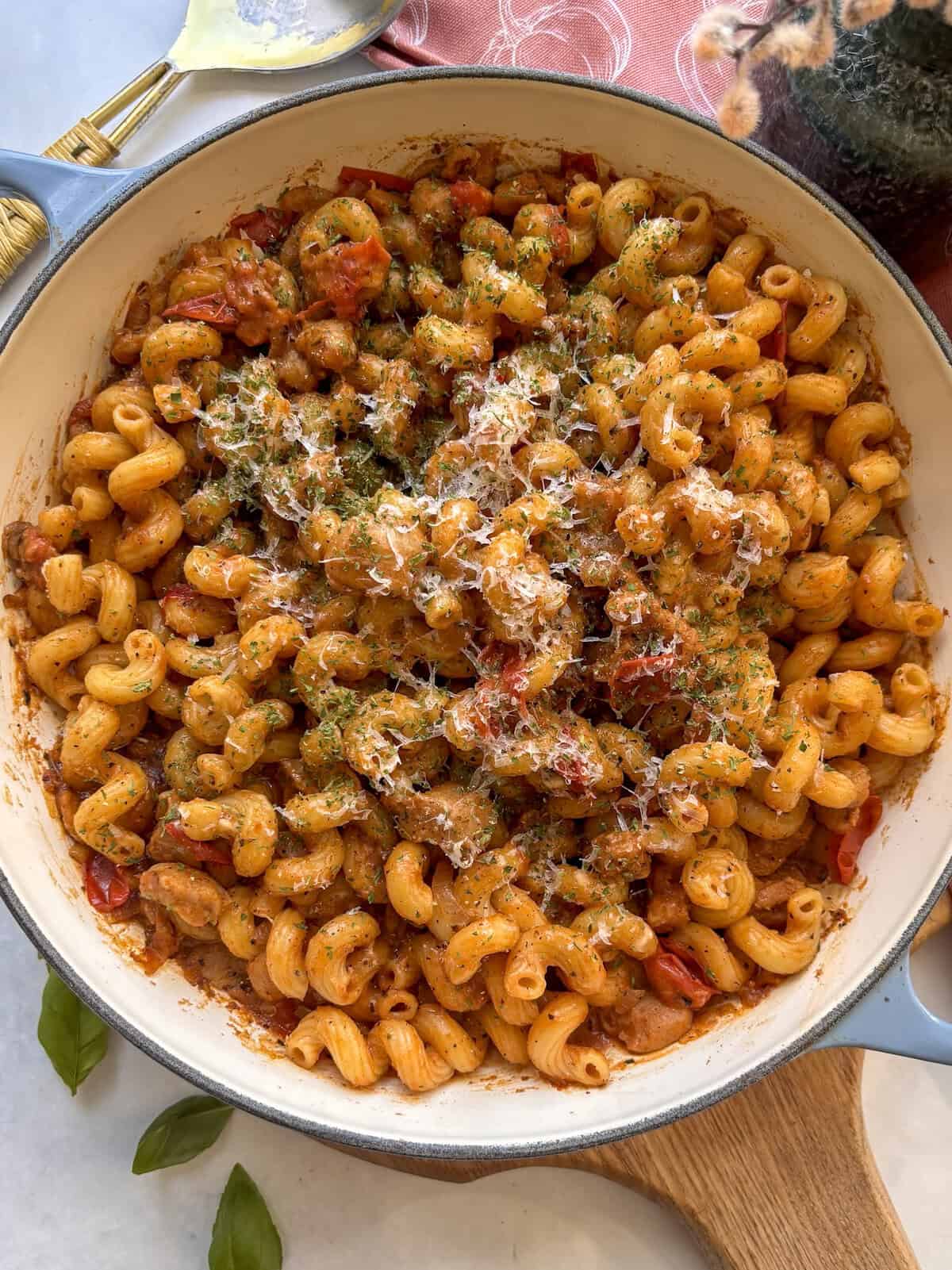 a dish of creamy sausage pasta topped with cheese and parsley