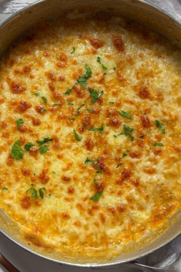 a pan of orzo mac and cheese with a golden and bubbly cheesy crust