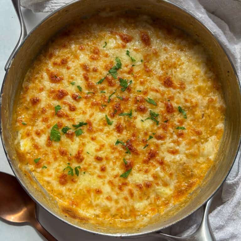 a pan of orzo mac and cheese with a golden and bubbly cheesy crust