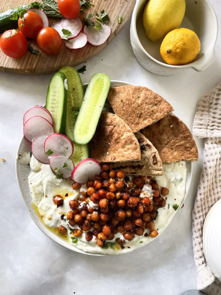 Harissa roasted chickpeas with whipped feta and freshly sliced salad vegetables.