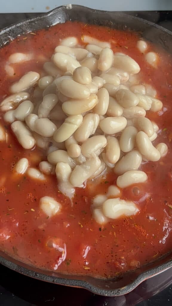 adding the white beans to the tomato sauce