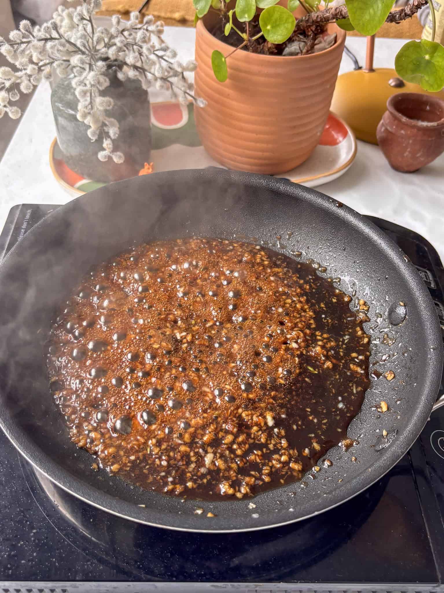 the honey garlic sauce cooking in a pan, beginning to bubble and thicken ready for the tofu to be added!