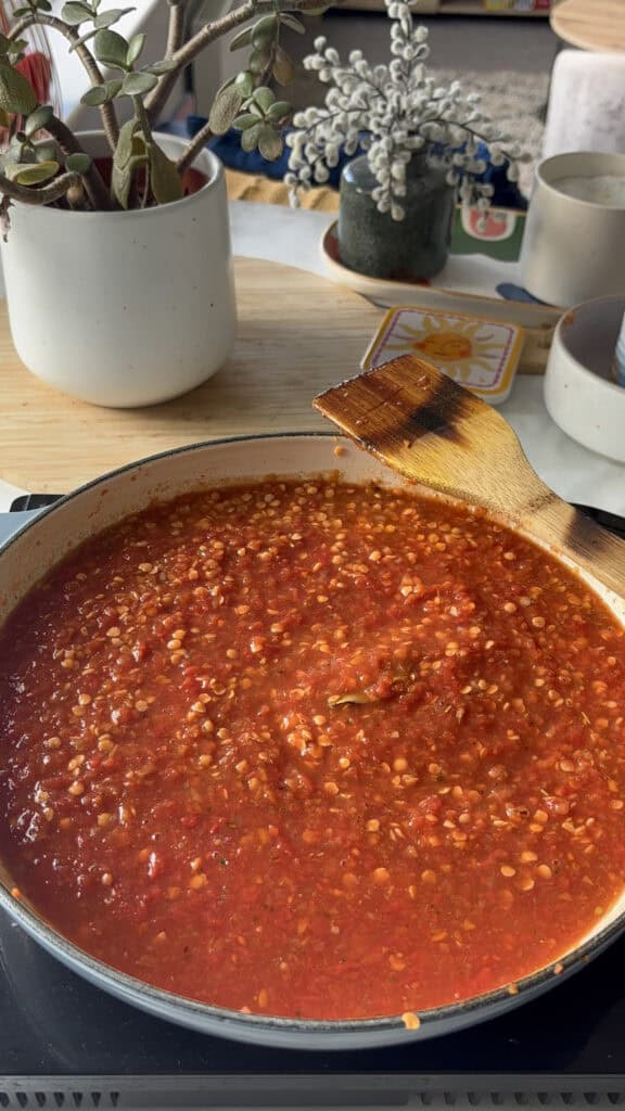 chopped tomatoes, vegetable stock, and bay leaves stirred into the lentil bolognese base. Ready to be simmered until thick and saucy