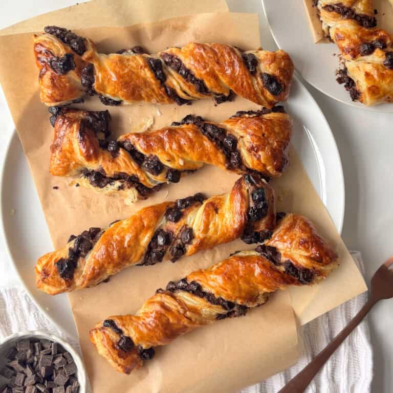 chocolate chips beside it and another plate of chocolate twists just in the corner of the shot