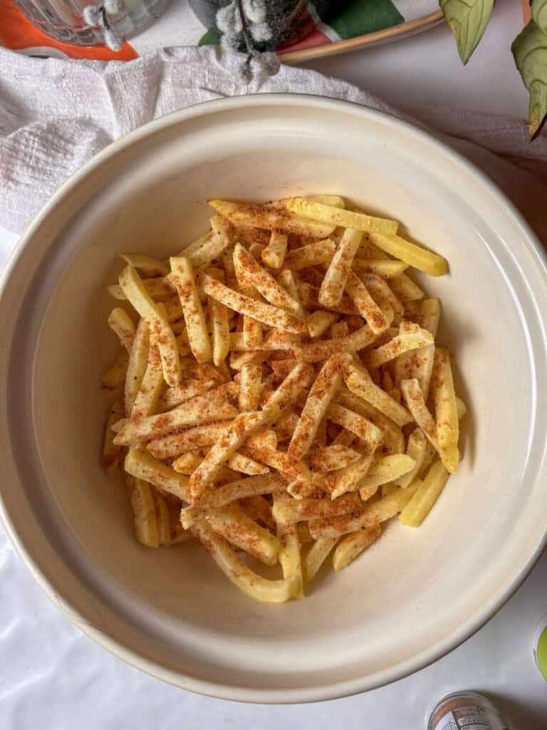 frozen French fries seasoned with Cajun seasoning in a bowl