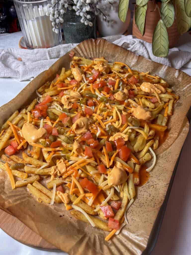 Frozen French fries topped with cheese sauce, pepper, tomato, cheese, jalapenos