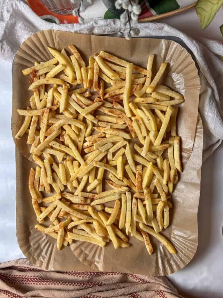the seasoned French fries on a baking tray