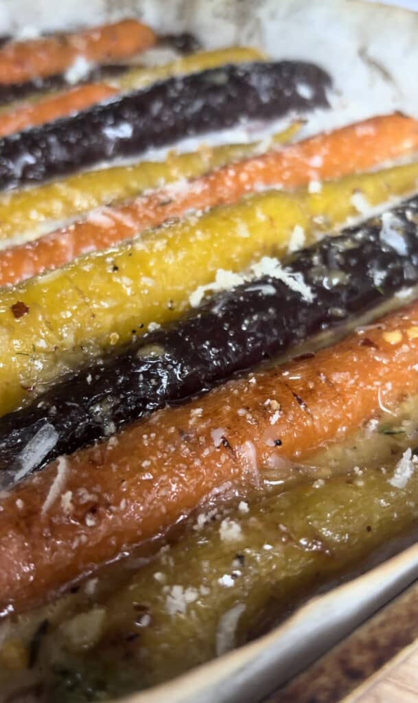 roasted honey carrots topped with breadcrumbs and cheese, ready to be cooked for another 10 minutes