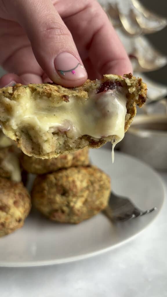 the centre of a cheesy vegetarian stuffing ball with melty brie cheese and cranberry sauce inside.