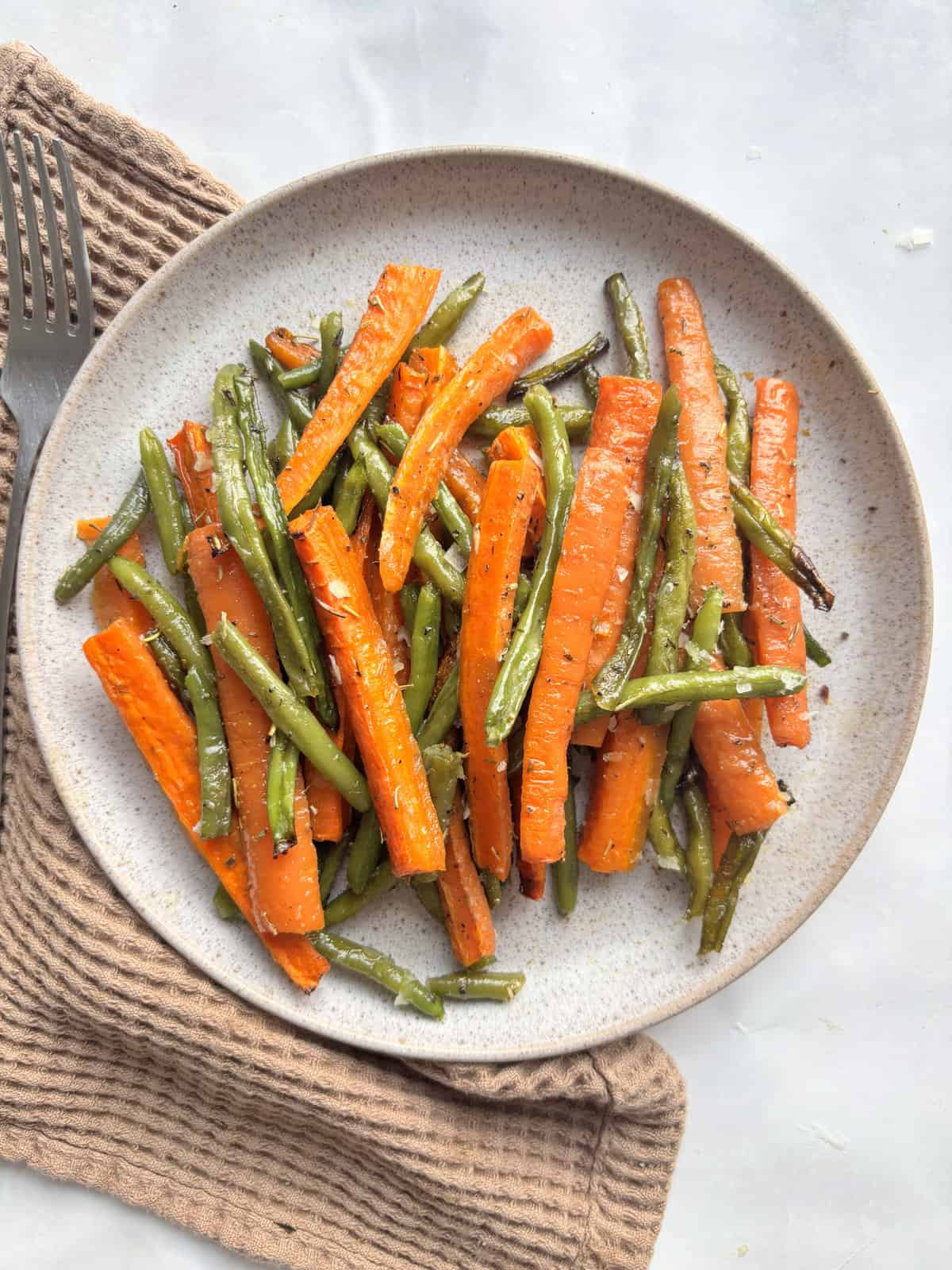 a serving plate of roasted green beans and carrots