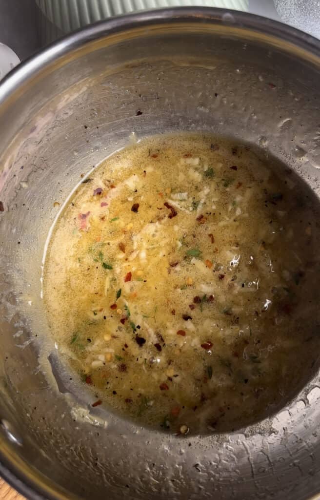a shot of the honey, garlic, chili, thyme, and butter sauce mixed up together in a silver saucepan