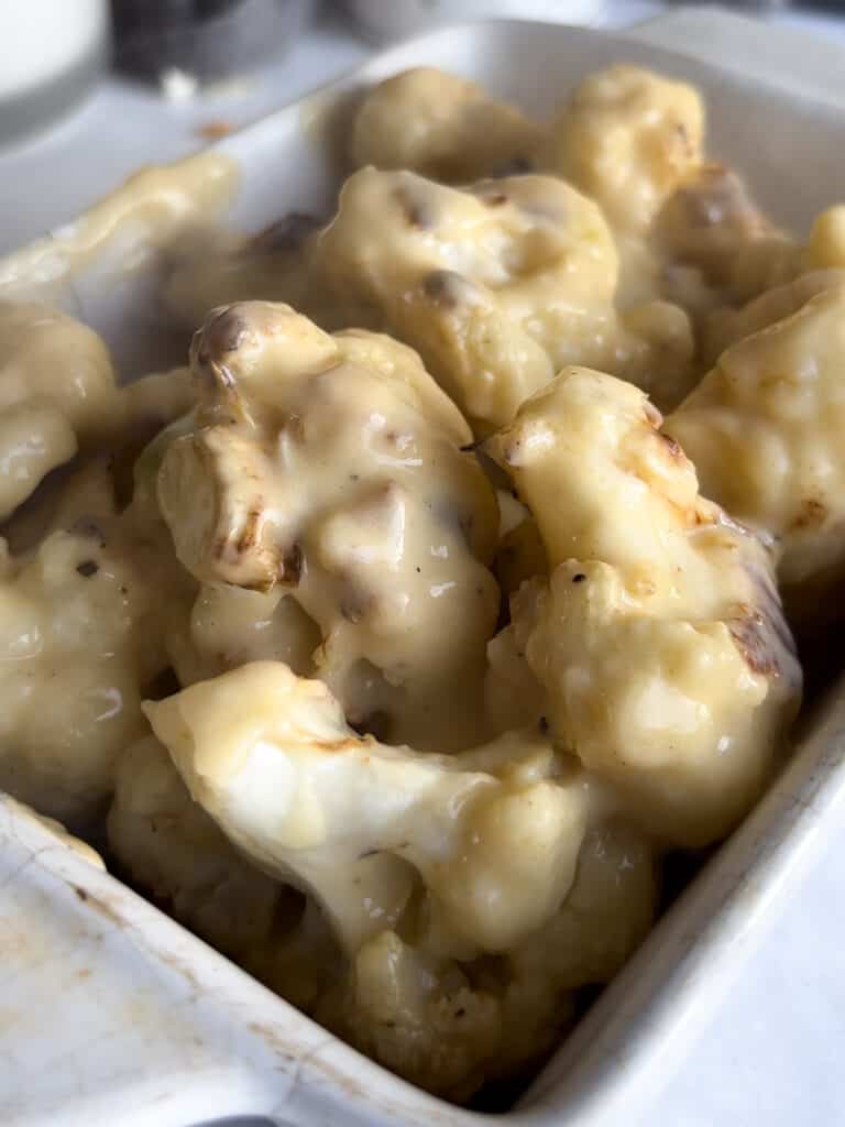 roasted cauliflower tossed in cheese sauce and added to a roasting dish