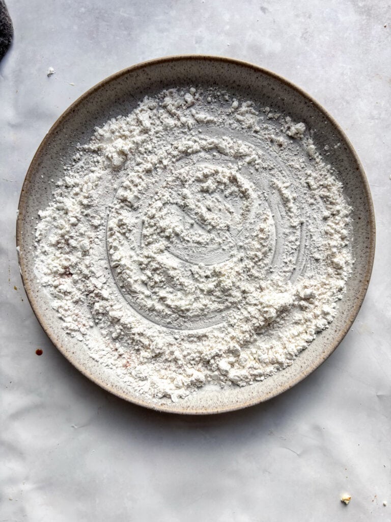 A small plate with the cornflour and seasonings spread over it