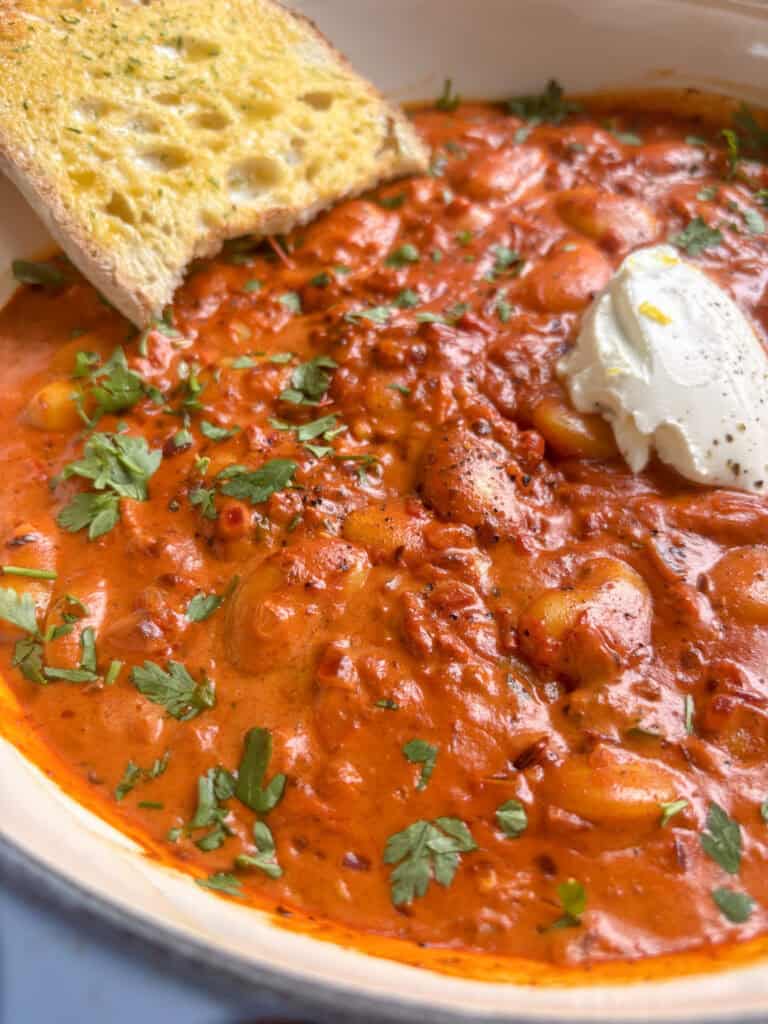 Creamy, smoky harissa butter beans topped with soft cheese and black pepper
