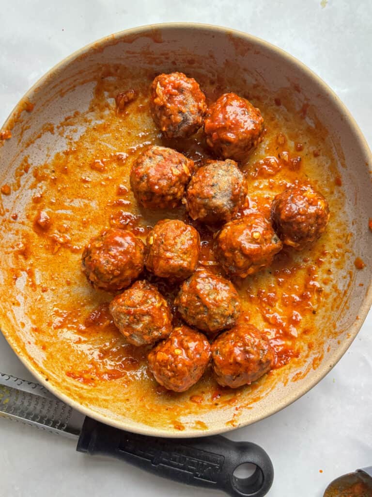 a bowl with the marinated harissa meatballs before cooking