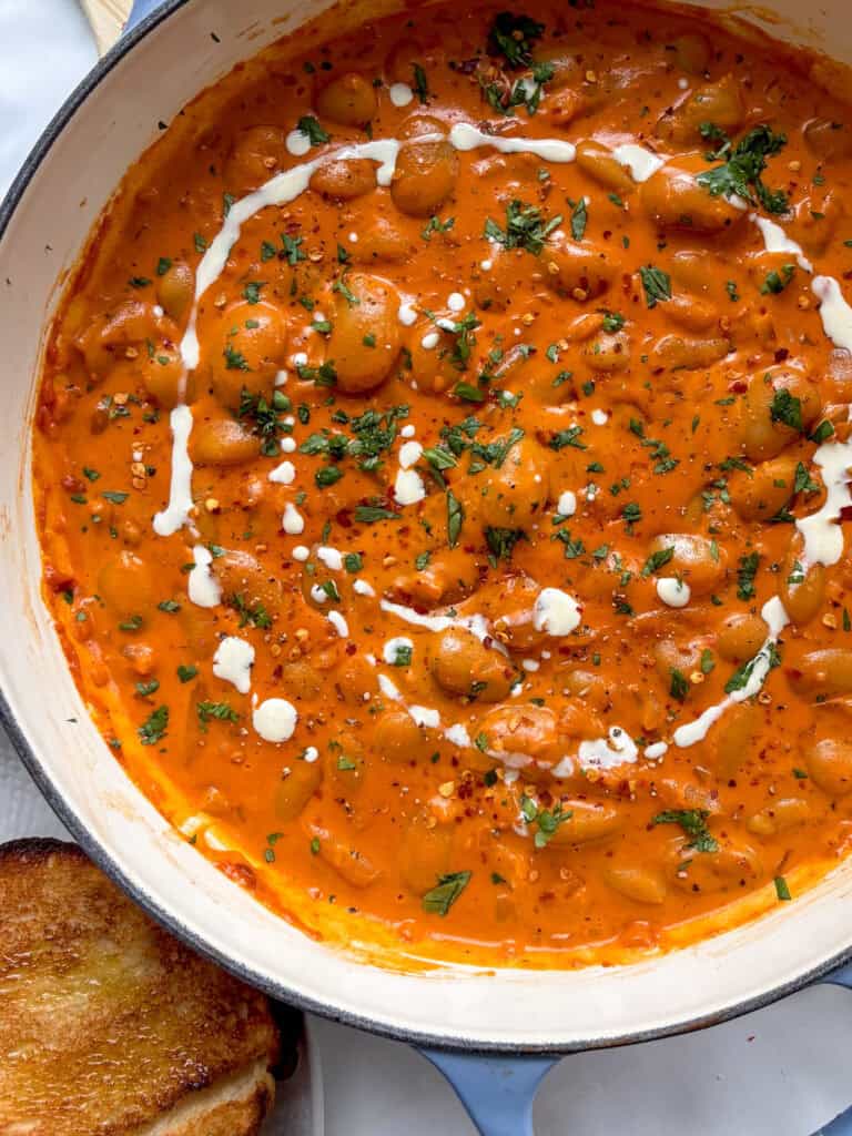 creamy beans alla vodka topped with red pepper flakes and parsley with a drizzle of cream