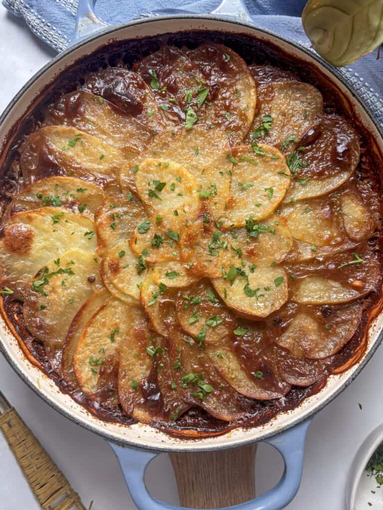 mushroom hotpot with crispy layered potato slices and fresh parsley scattered over the top
