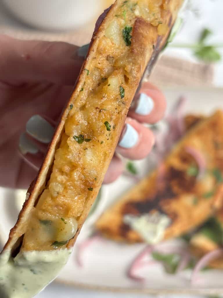 a close up shot of a potato taco, filling side up