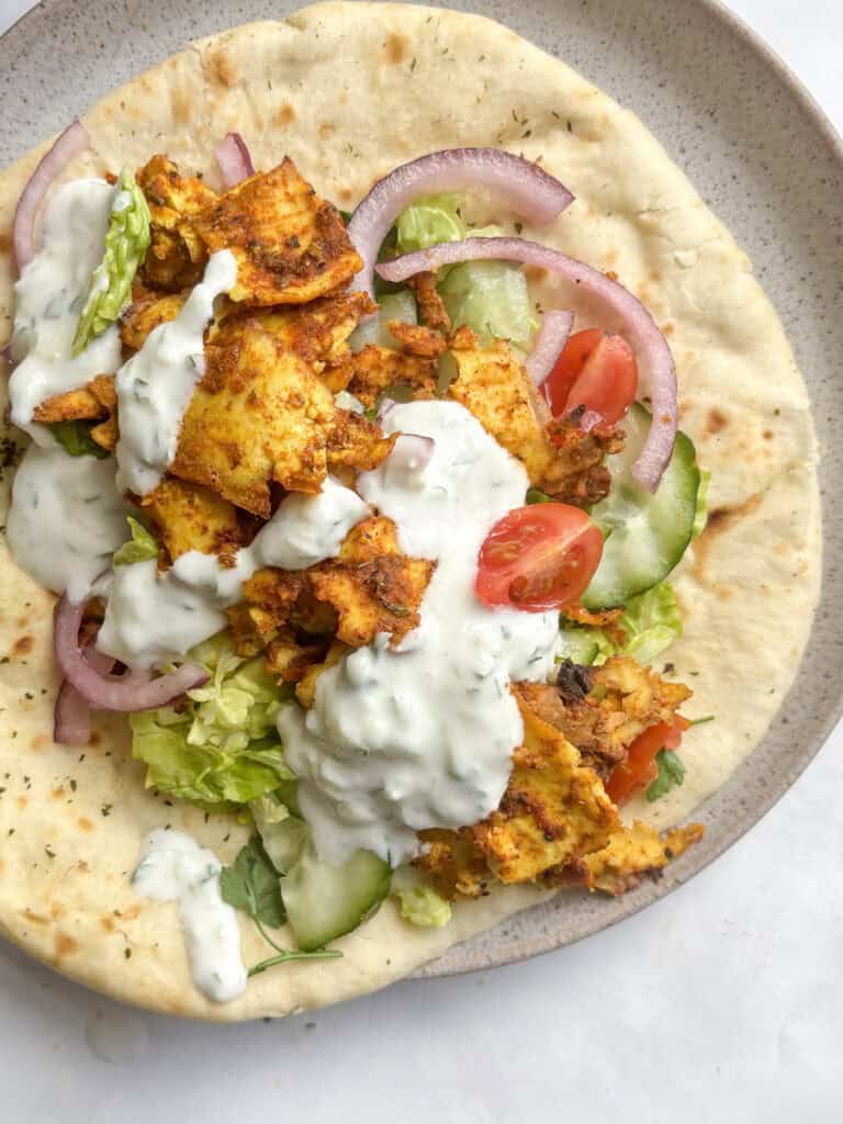 tofu shawarma on a flatbread with salad and tzatziki sauce