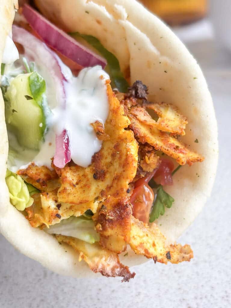 a tofu shawarma flatbread with salad and tzatziki sauce