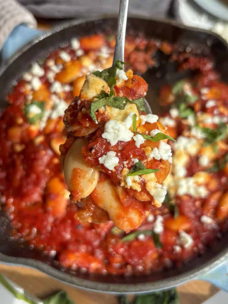 a spoonful of the giant baked beans sprinkled with feta and parsley