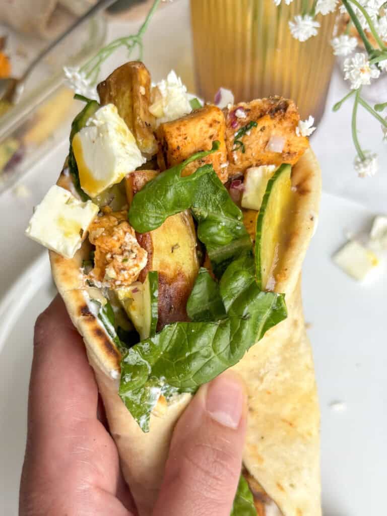 vegetarian chicken gyro close up loaded with cucumber, lettuce, vegan chicken, fries, and feta