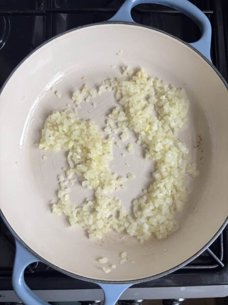onion and garlic being sauted in a pan