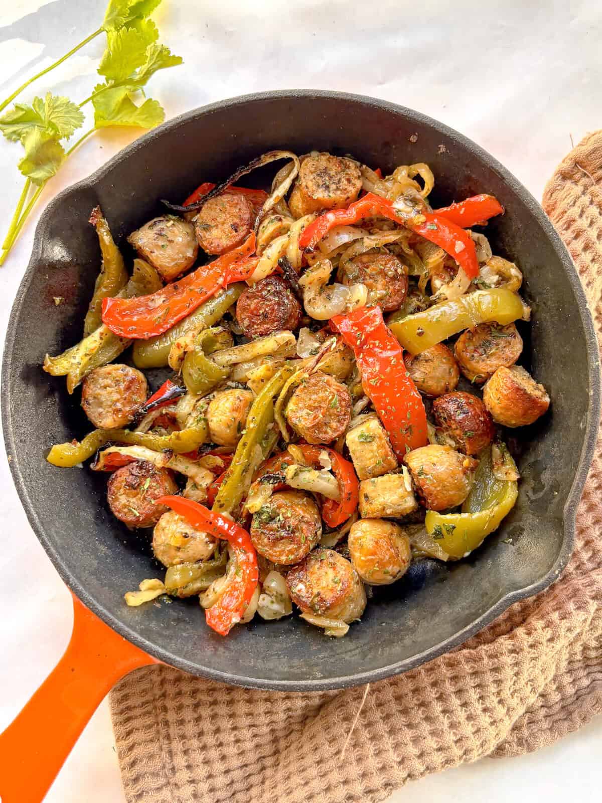 a cast iron skillet of sausage and peppers