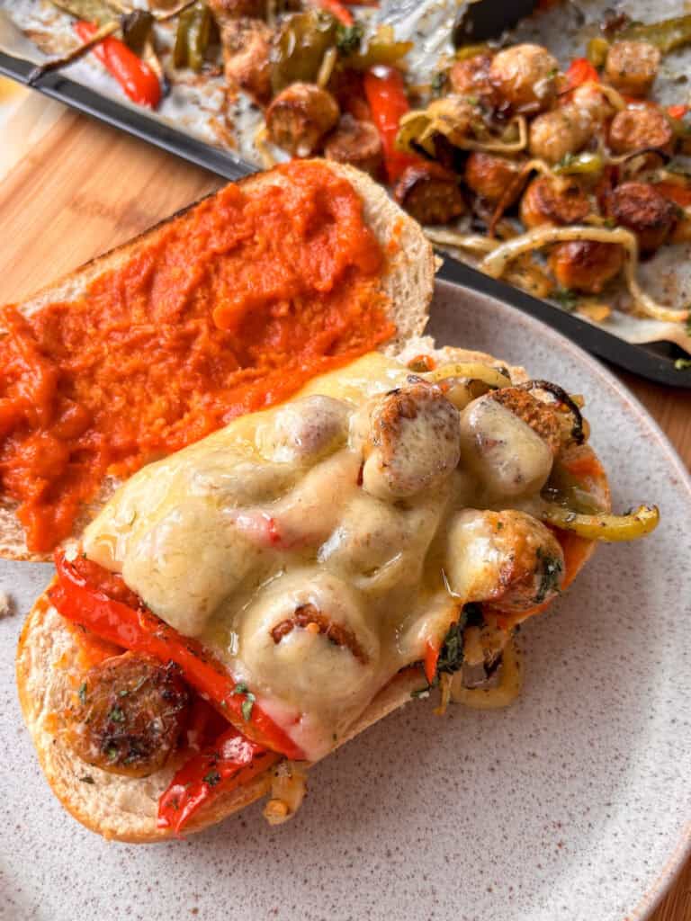 sausage and peppers served on a roll with marinara sauce and melted cheese