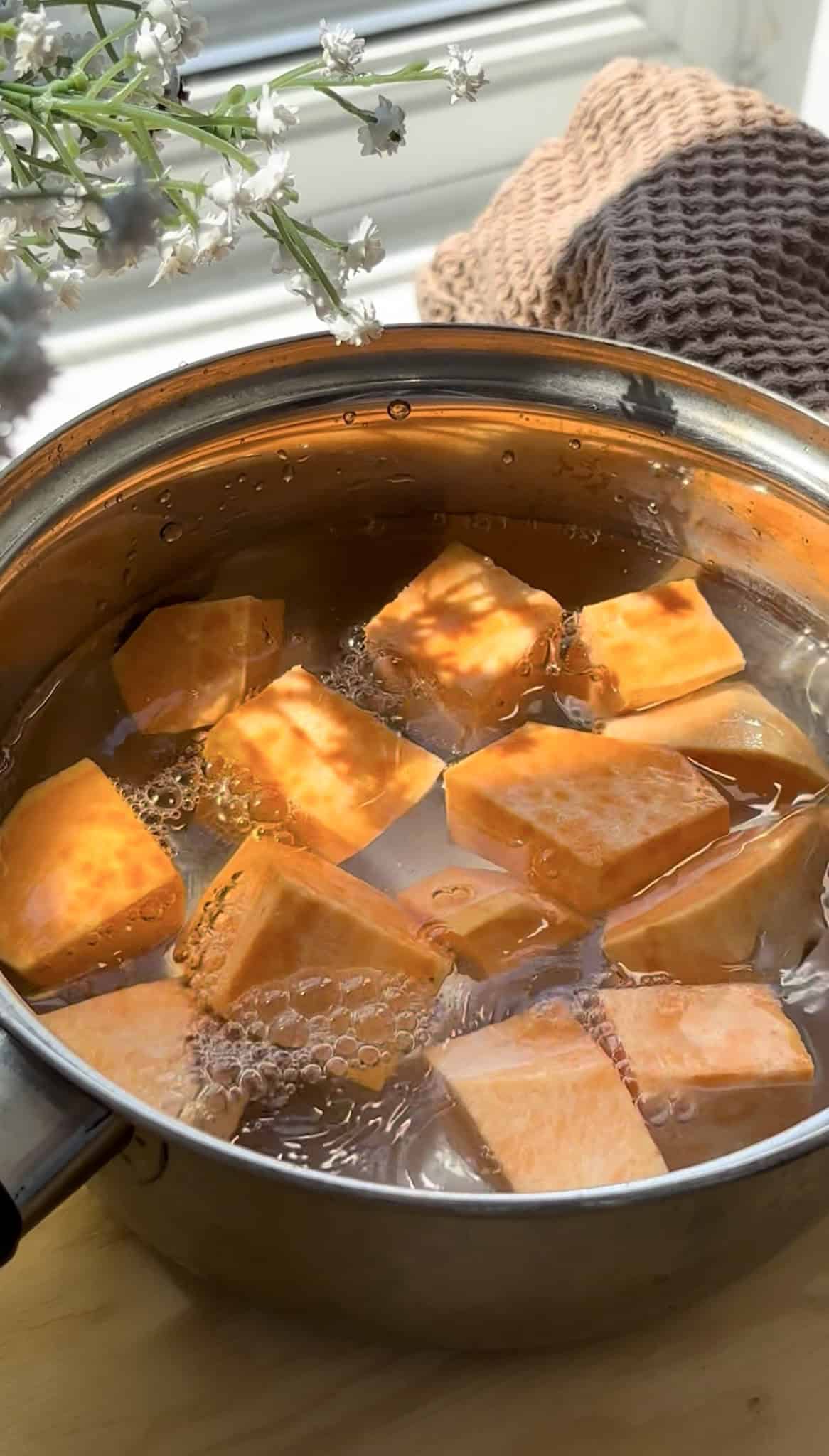 cubed sweet potato being boiled in a saucepan