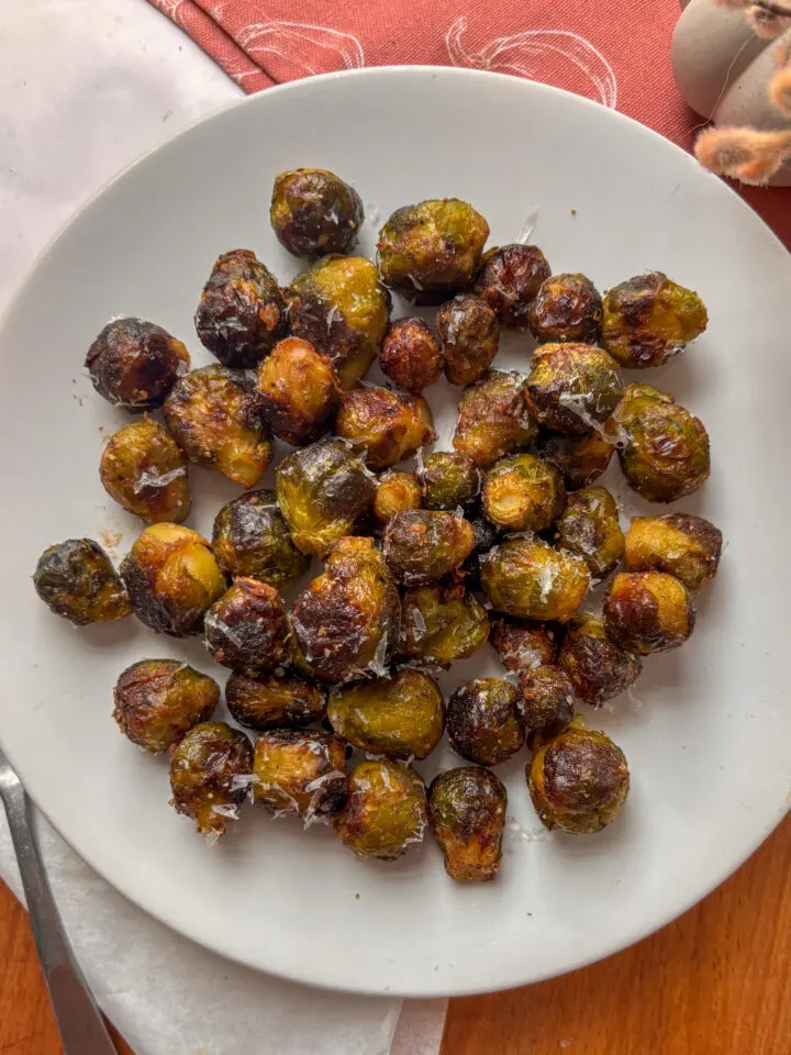 Roasted Brussels sprouts with caramelized edges served on a white plate as a dinner side dish.