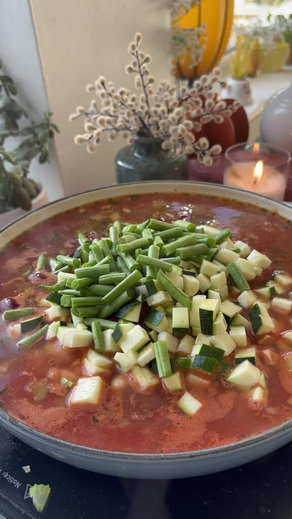 garden vegetables - zucchini and green beans - added to the pan
