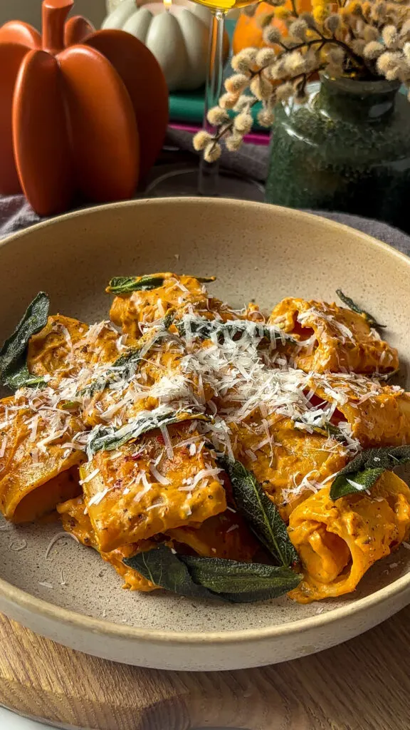 pumpkin pasta alla vodka in a pasta bowl with grated cheese on top