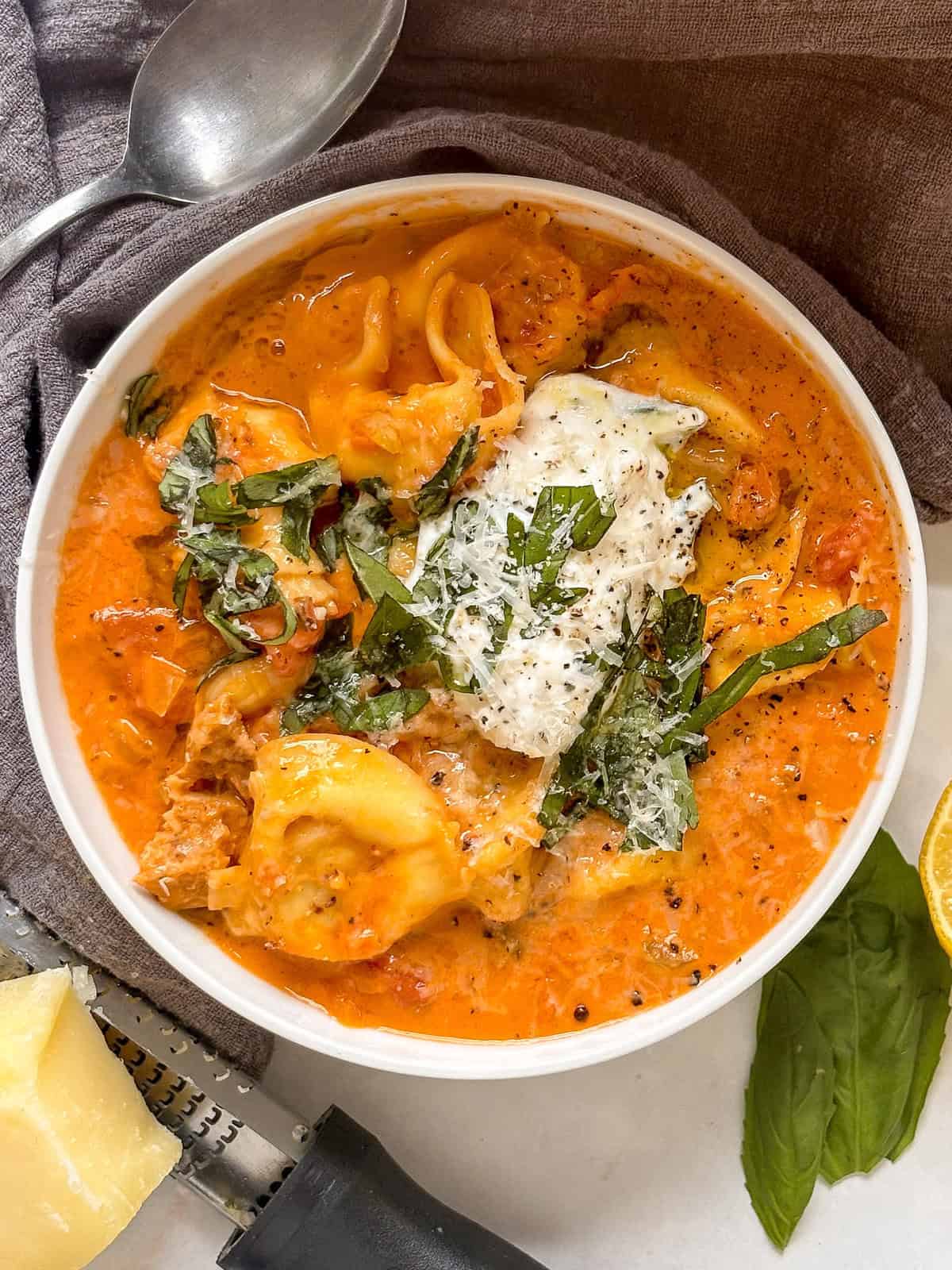 creamy tortellini soup with cheese tortellini, white beans, crumbled sausage,in a creamy tomato sauce topped with ricotta and basil