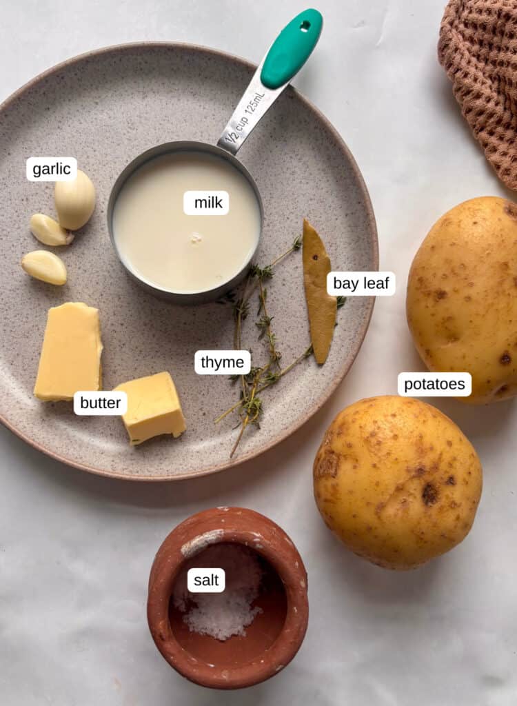 garlic mashed potatoes ingredients with potatoes, thyme, bay leaf, salt, butter, garlic, milk