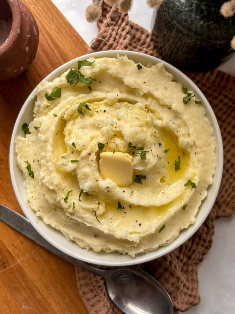 an overhead shot of the garlic mashed potatoes, topped with parsley, black pepper and butter