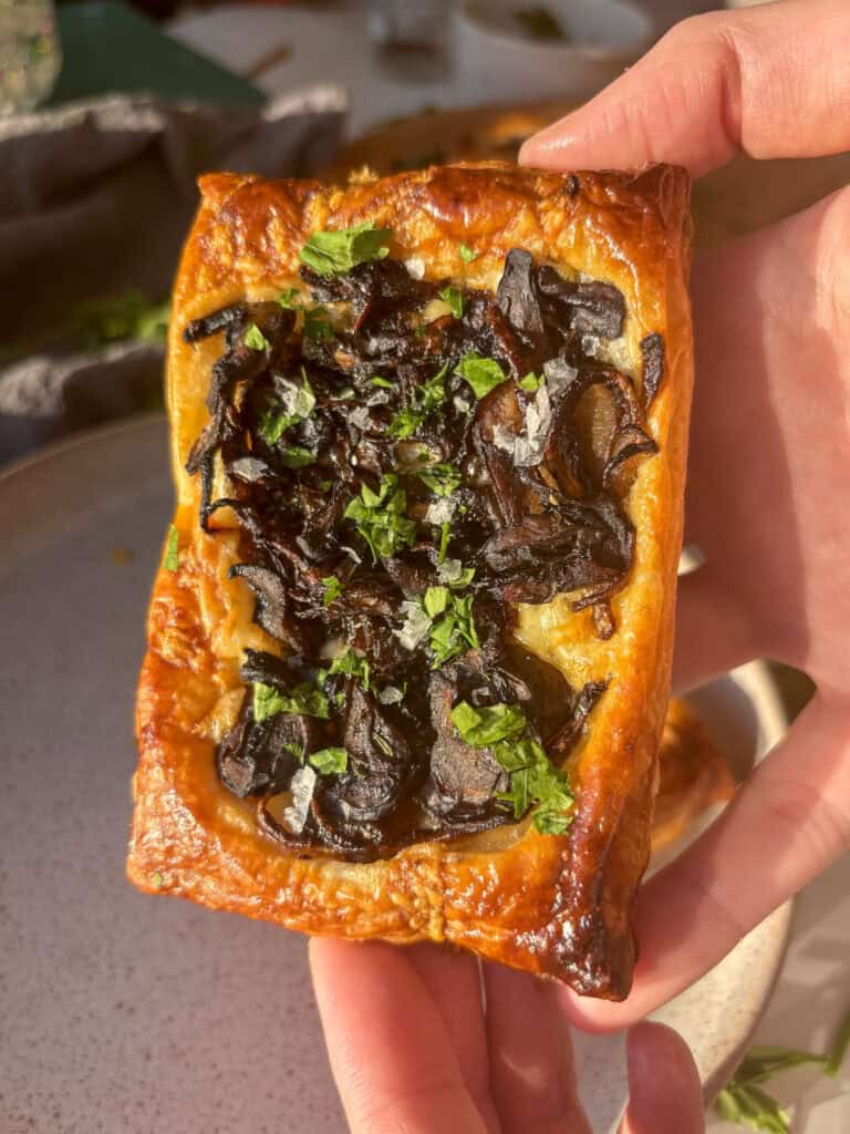puff pastry tart with cheddar cheese and caramelized onion mushrooms on top