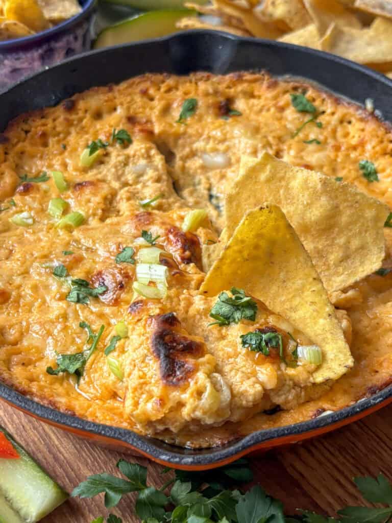 white bean buffalo dip with a tortilla chip in it