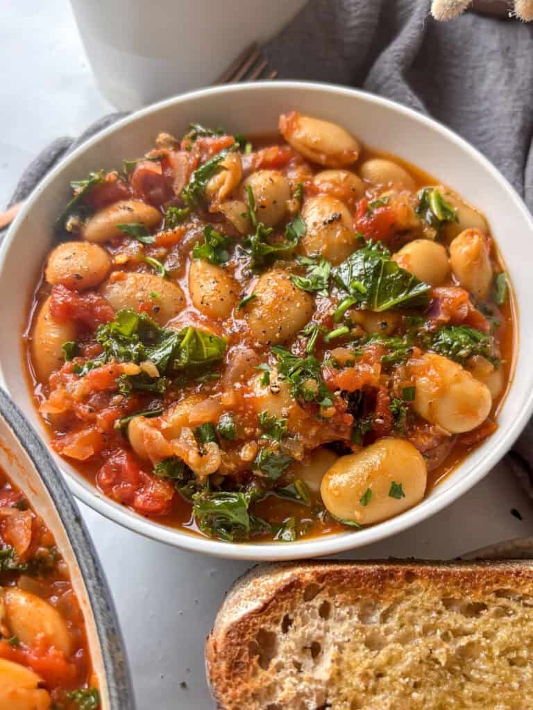 white bowl of butter bean and kale stew