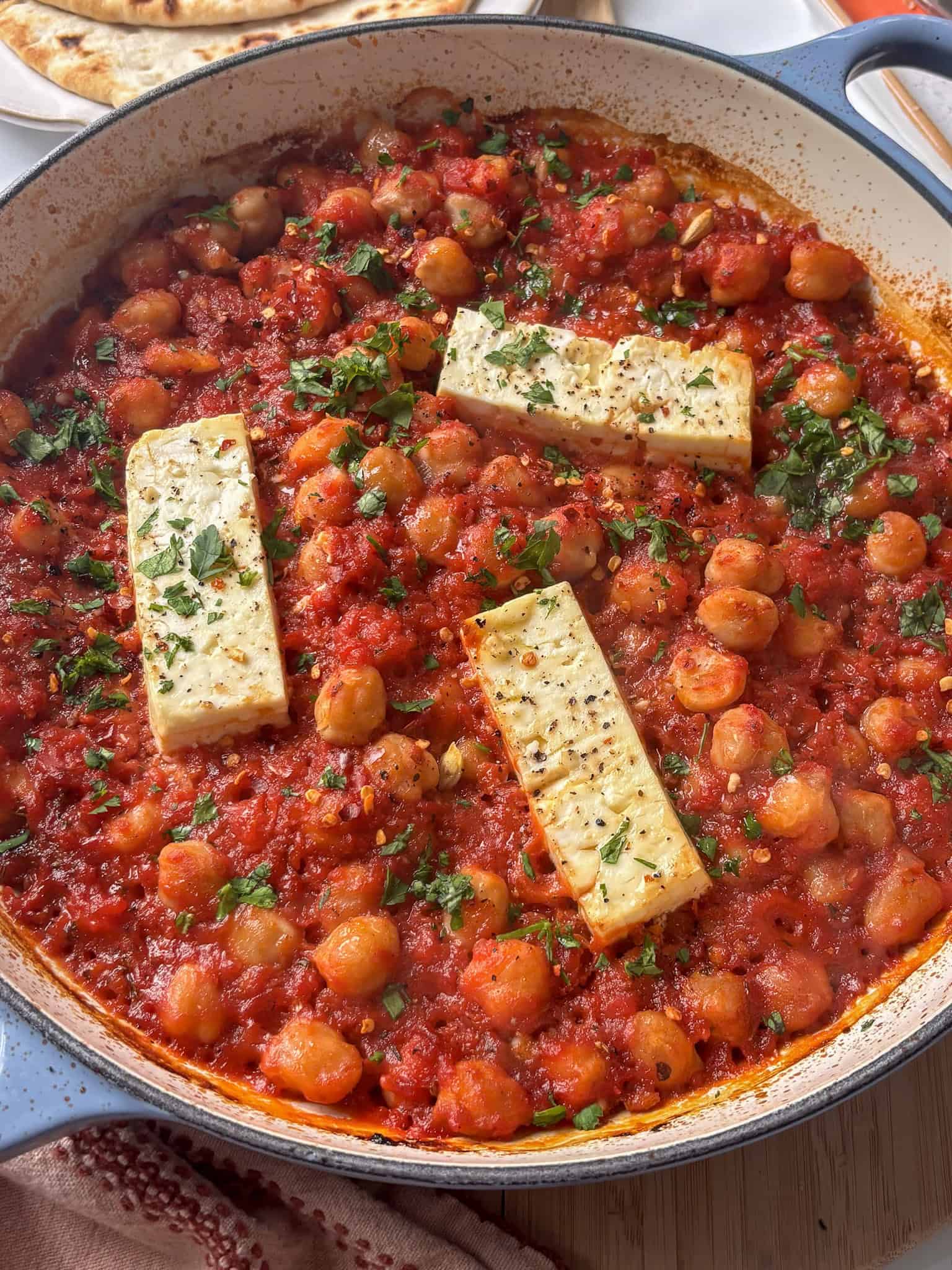 a casserole pan of baked feta with chickpeas in a tomato harissa sauce