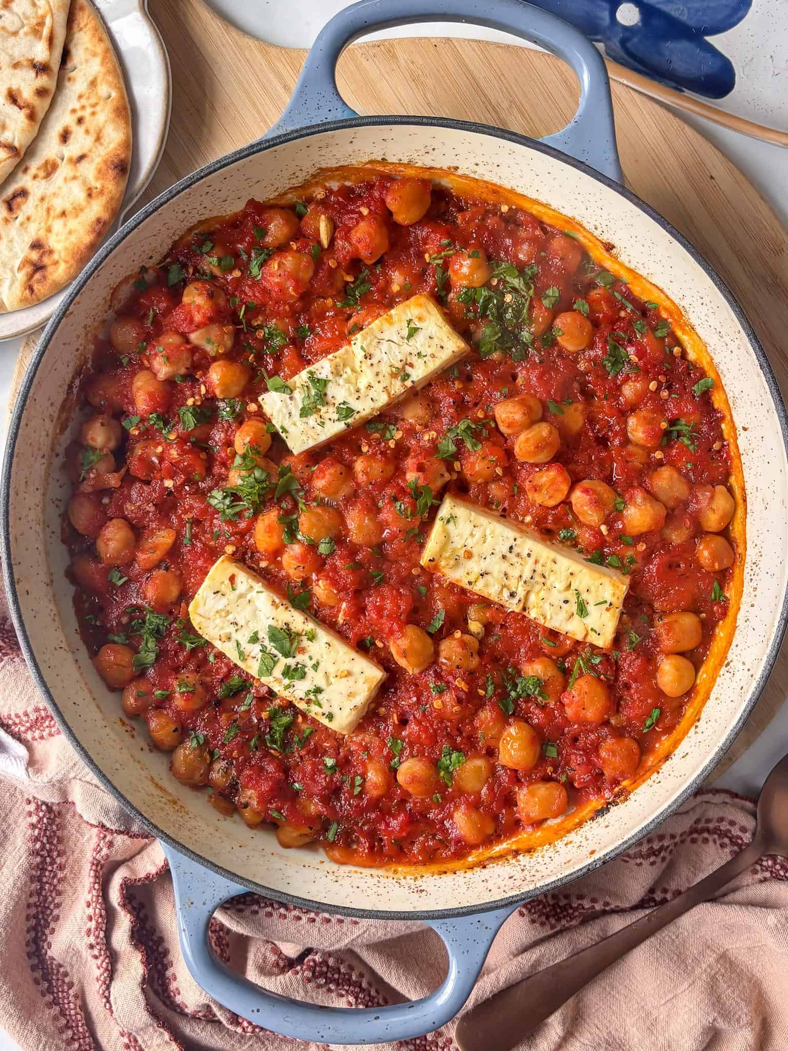 a casserole pan of baked feta chickpeas topped with fresh parsley