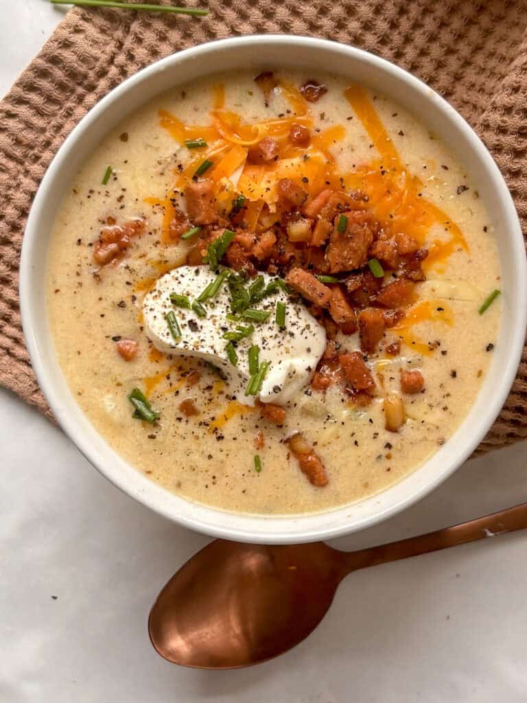 loaded baked potato soup loaded with sour cream, vegan bacon, cheese, and chives