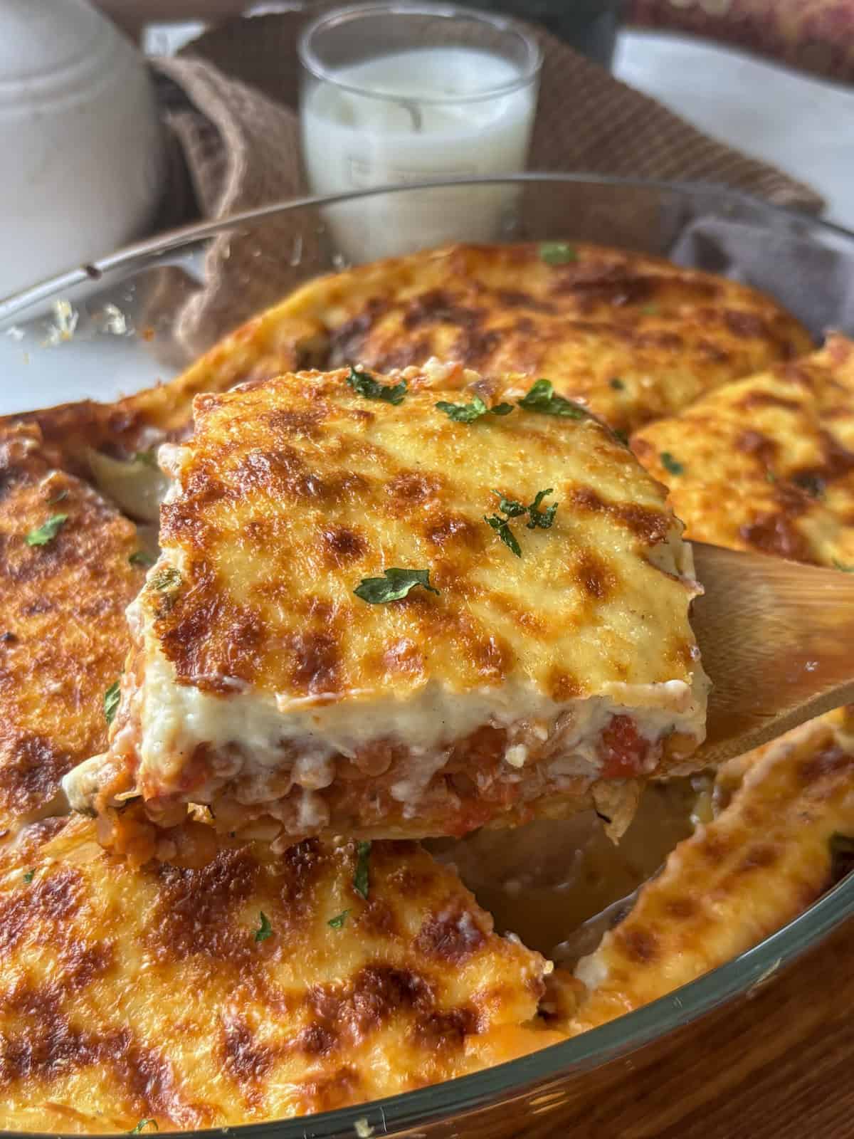 a slice of vegetarian moussaka being lifted out of the pan